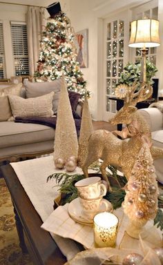 a living room decorated for christmas with gold decorations on the coffee table and trees in the background