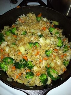 rice and vegetables cooking in a skillet on the stove