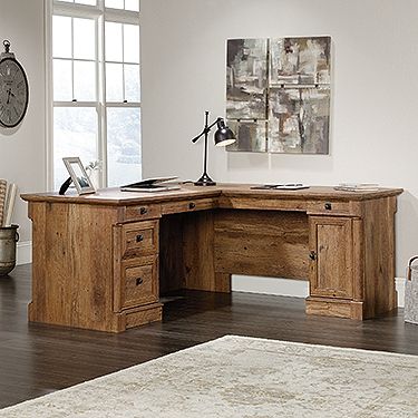 a wooden desk sitting on top of a hard wood floor next to a white rug