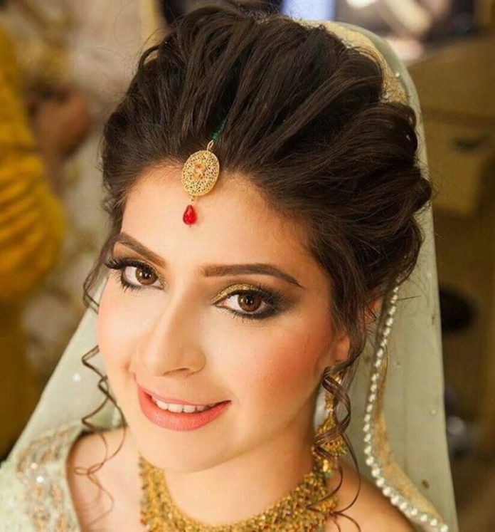 a woman wearing a bridal outfit and jewelry