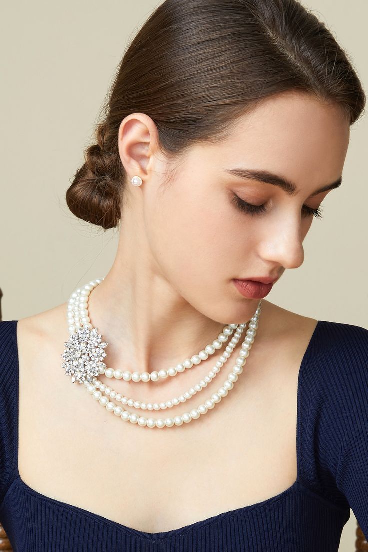 This sumptuous piece of jewelry features a retro-elegant yet slightly modern style that complements the lavish garments, reminiscent of the roaring 1920s. Features: Lustrous imitation pearls Necklace and earrings set Rhinestone studded flower pattern Pearl strand lengths: 15.3", 17.1", 18.1" Elegant Beaded Round Bridal Necklace, Elegant Pearl Jewelry For Parties, Glamorous Pearl Bridal Necklace For Formal Occasions, Elegant Crystal Pearl Necklace For Party, Elegant Pearl Pendant Jewelry For Party, Elegant Pearl Pendant For Party, Glamorous Pearl Necklace For Formal Occasions, Vintage Pearl Bridal Necklace For Party, Elegant Pearl Jewelry For Vintage Events