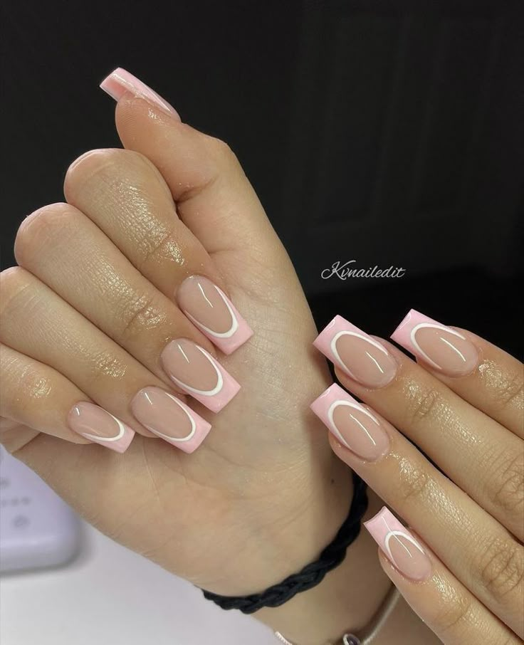 a woman's hands with pink and white manies on their nails, holding her hand up to the camera