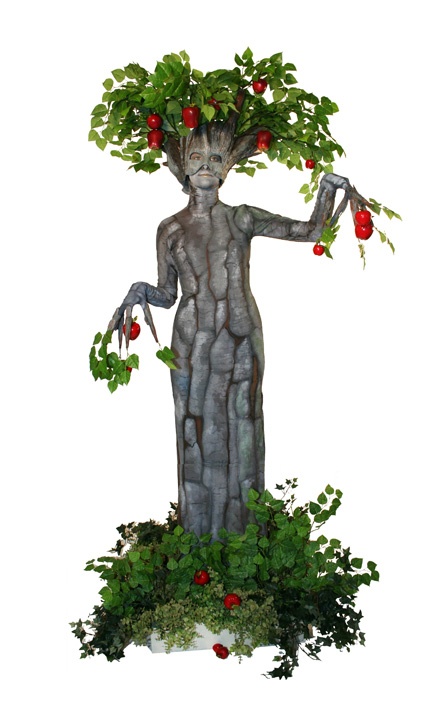 a statue with fruit growing on it's head and hands in the shape of a tree