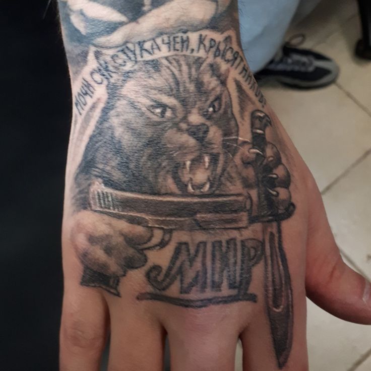 a person's hand with a tattoo on it that has an image of a wolf