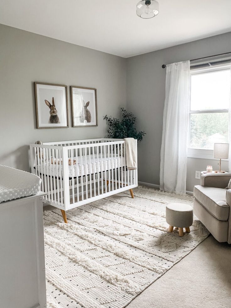 a baby's room with a white crib and gray walls