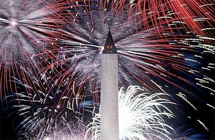 fireworks are lit up in the night sky behind a light tower with a clock on it