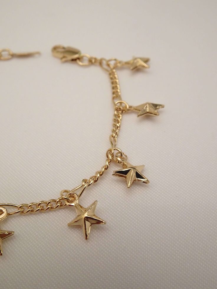 The stars lined up when this beauty was created! The Star Bracelet is one superstar! This star charm bracelet features an infinity dainty bracelet adorned with tiny puff star charms. Best of all, she comes in anklet form too! Your sure to stir a sensation with this cutie! Knock this look out of this galaxy with these must have star jewelry pieces too! - The Star Choker Necklace - The Starburst Earrings - The Moon and Star Necklace Available in 24K gold or rhodium plating over steel Size: 7" (we Gold Anklet With Star Charm As Gift, Gold Anklets With Star Charm For Gift, Star Charm Anklets As Gift, Star Charm Anklets Suitable As A Gift, Star Charm Anklets For Gifts, Gold Star Charm Chain Bracelet, Gold Chain Bracelet With Star Charm, Adjustable Gold Chain Bracelet With Star Charm, Gold Star Charm Bracelet