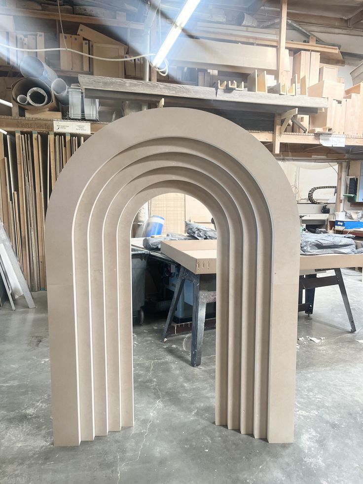 an arch shaped sculpture in the middle of a workshop