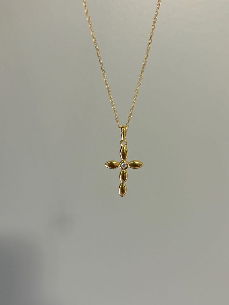 Dainty and shiny, our cross necklace is highly polished and perfect for daily wear! Information: ✨ Sterling Silver (925 stamped) | 14K Gold Plated ✨ AAA grade Cubic Zirconia gemstone ✨ Adjustable length: 16" - 18" ✨ Hypoallergenic ✨ Tarnish resistant ✨ Water friendly Our cross necklace is dainty, roughly the size of a quarter which makes it ideal for those that love small charms. The necklace features great craftsmanship and attention to detail. At the center of the cross, an AAA Cubic Zirconia gemstone is placed giving the charm more brilliance. Once you see the necklace, there is no doubt about the quality. Plus, the necklace is adjustable. You have the ability to wear it at 16", 17" or 18" allowing you to find your perfect fit. For centuries, Christians have seen the cross as a symbol o Cross Necklace Dainty, Dainty Cross Necklace For Baptism, Minimalist Cross Pendant Necklaces For Baptism, Minimalist Cross Pendant Necklace For Baptism, Dainty Cross Pendant Necklace For Baptism, Sterling Silver Cross Necklace For Baptism, Dainty Yellow Gold-plated Cross Necklace, Gold-tone Cross Necklace Gold Plated, Elegant Gold-tone Cross Necklace