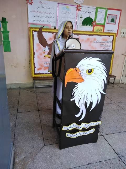 a woman standing behind a podium with an eagle painted on it