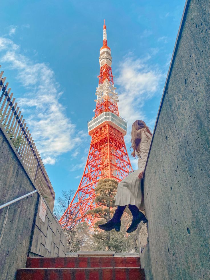 a woman is walking up some stairs in front of the eiffel tower