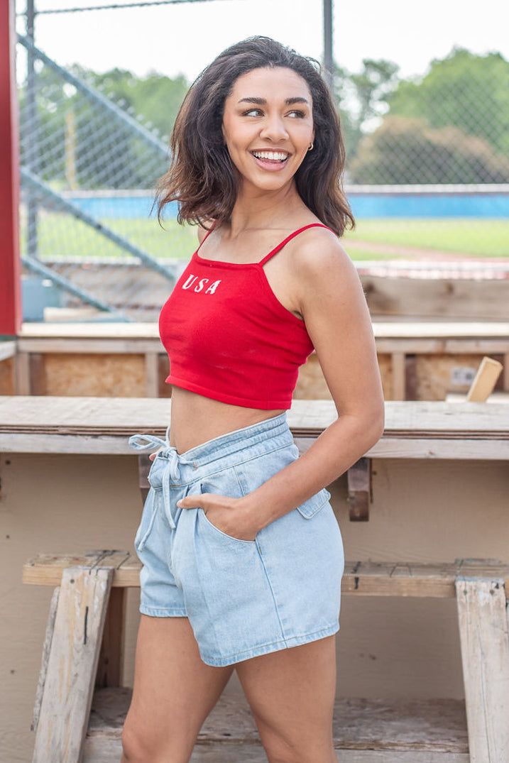 Celebrate the Fourth of July with our new USA Crop Top! This new arrival features a soft knit material, a square neckline, cami adjustable straps, and a cropped length. Pair this one with your favorite denim! Available in navy and red. cotton nylon hand wash with cold water lay flat to dry iron if needed Models are wearing a size small Casual Crop Top With Tank Straps, Red Trendy Camisole Crop Top, Trendy Red Camisole Crop Top, Casual Red Tank Strap Tops, Casual Cotton Camisole Crop Top, Casual Camisole Crop Top For Day Out, Casual Cropped Camisole For Day Out, Casual Red Crop Top, Red Casual Camisole Crop Top