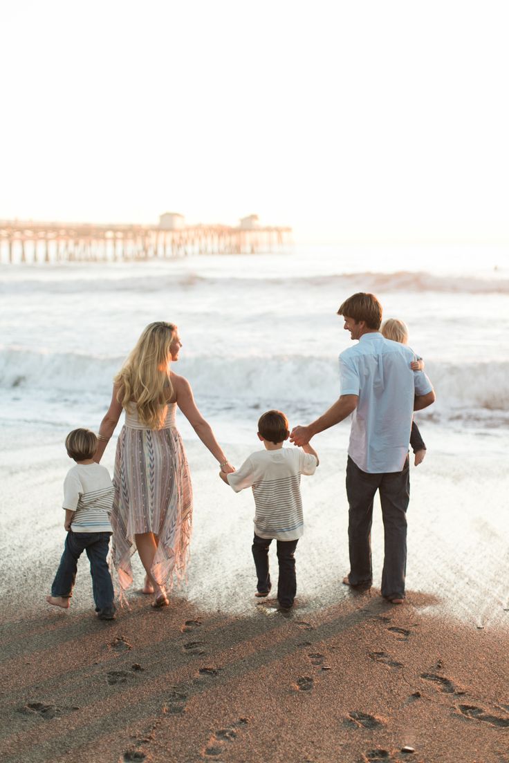 a family walking on the beach holding hands