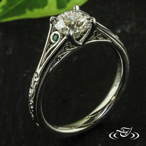 a white gold engagement ring with an old - fashioned style diamond and green sapphire stones