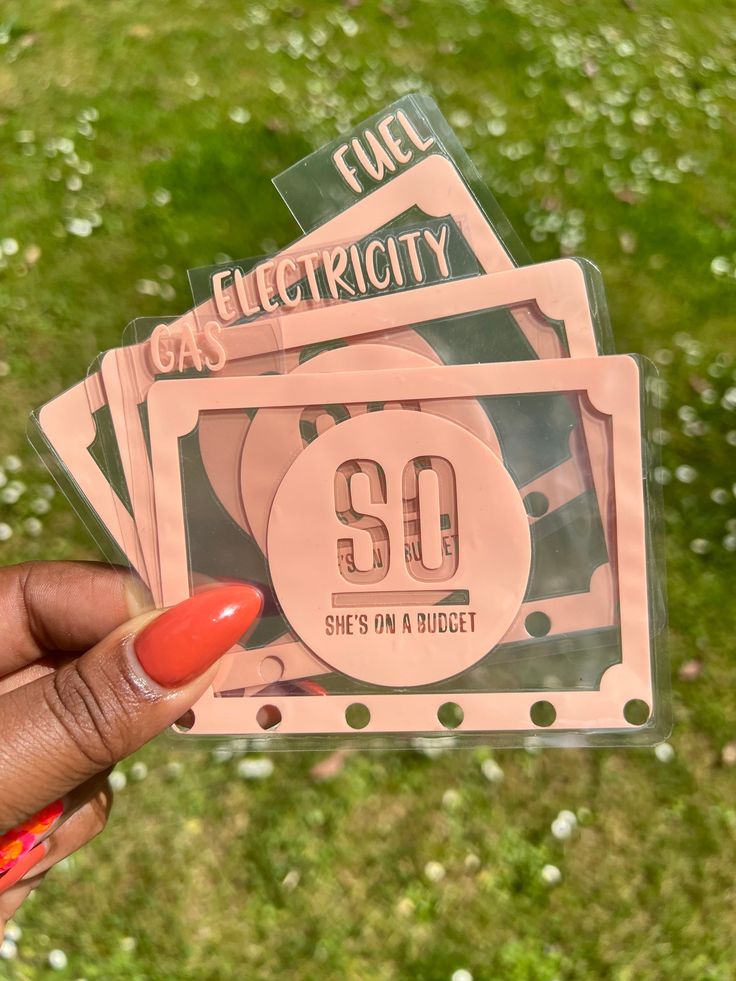 a person holding up some pink stickers in their hand with the number 50 on them