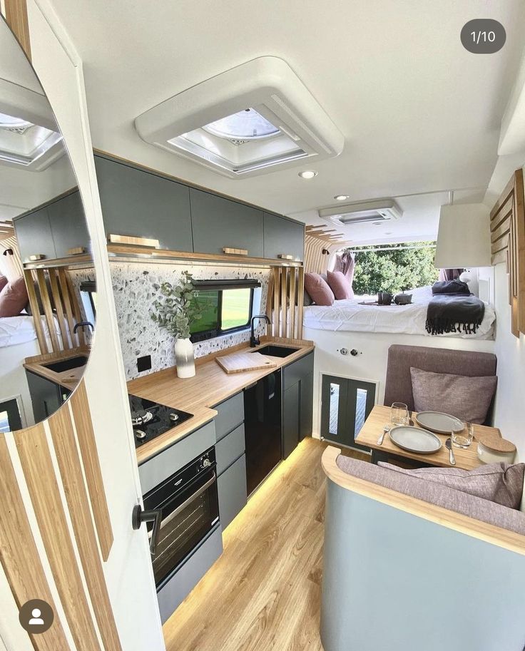 the interior of an rv with wood flooring and white walls is shown in this image