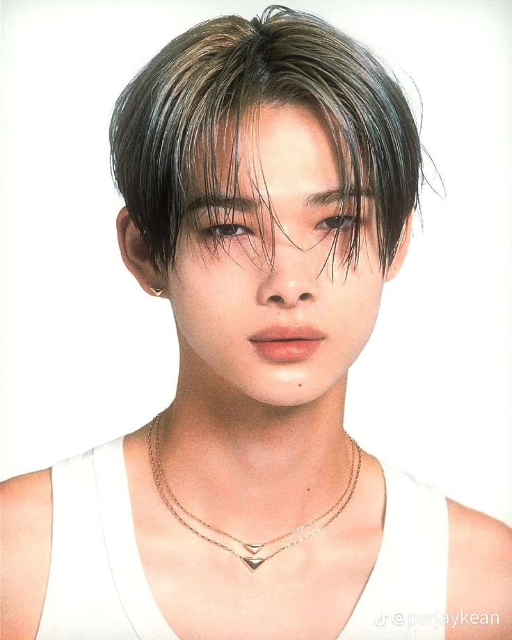 a young man with short hair wearing a white tank top and gold chain necklace on his neck