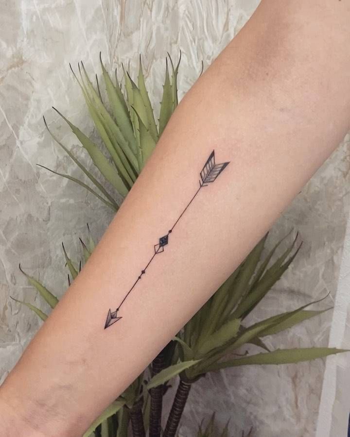 an arrow tattoo on the arm