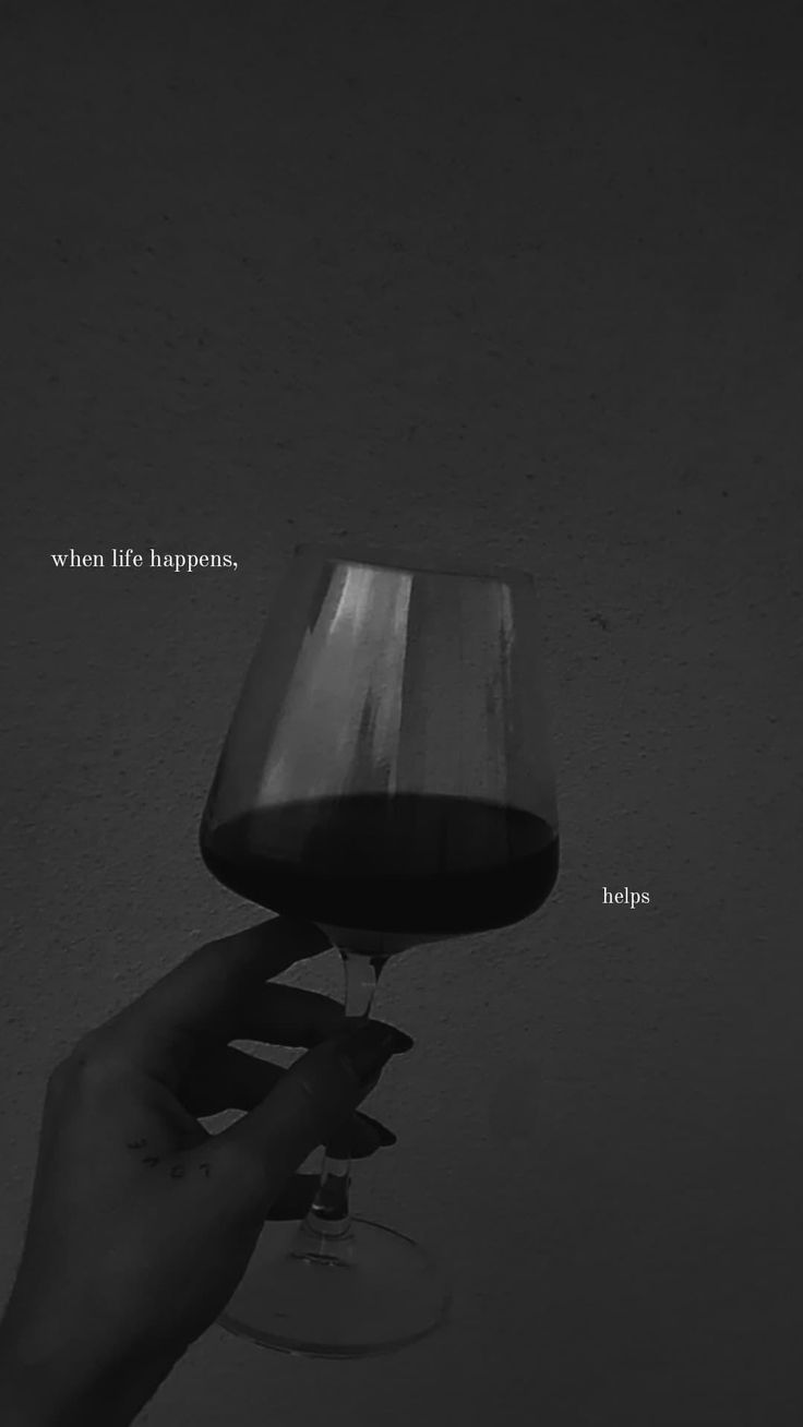 a hand holding a wine glass in front of a wall with the words, when life happens