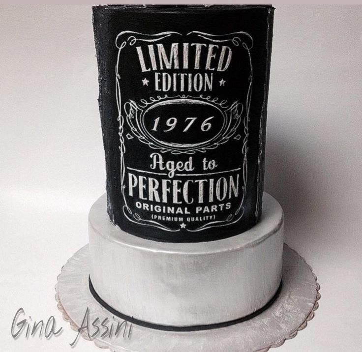 a black and white birthday cake with an aged to perfection label