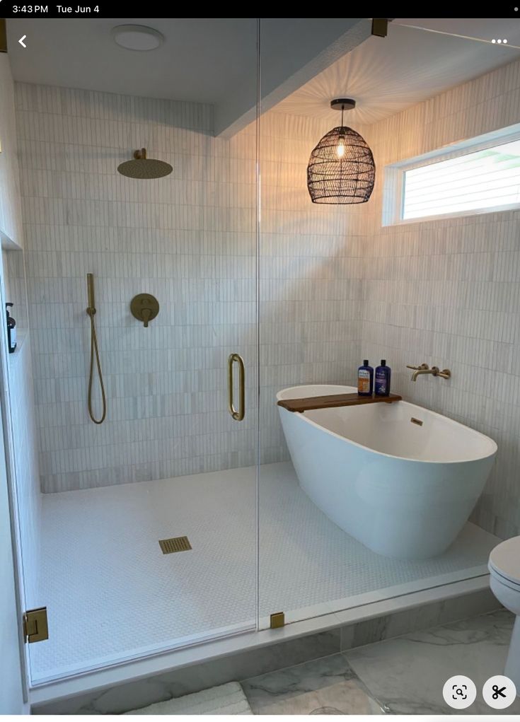 a white bath tub sitting next to a walk in shower