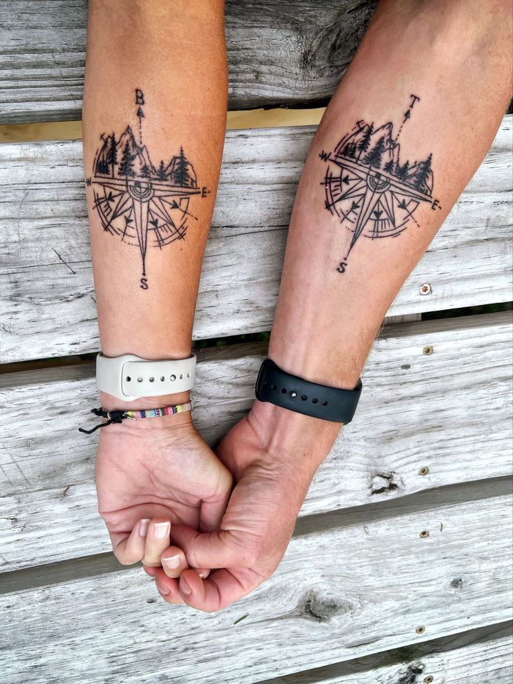 two people holding hands with compass tattoos on their wrists and wristbands, both wearing bracelets