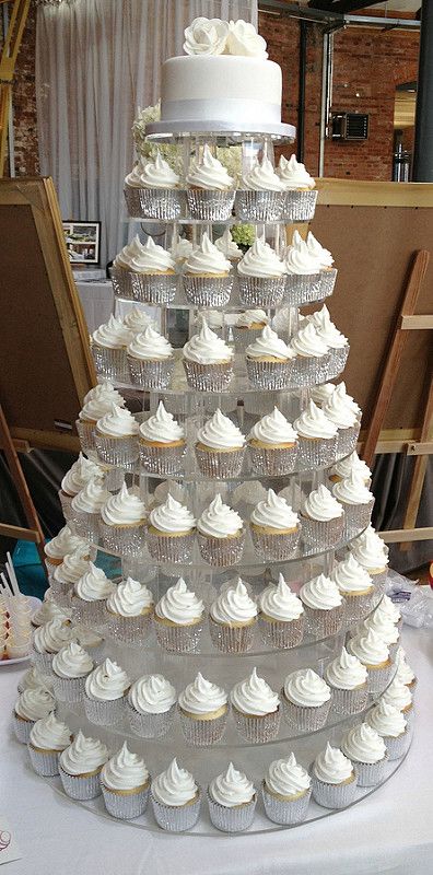 a large cake made out of cupcakes sitting on top of a table