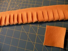 an orange piece of fabric sitting on top of a cutting board