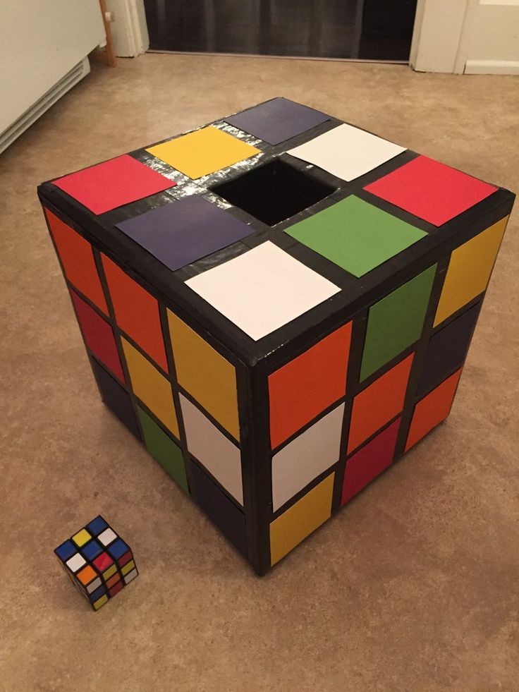 a rubik cube is sitting on the floor next to a toy