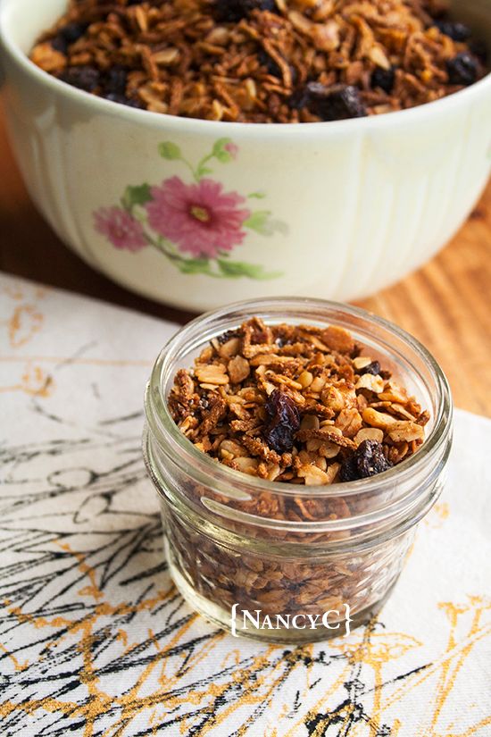 a glass jar filled with granola sitting on top of a table