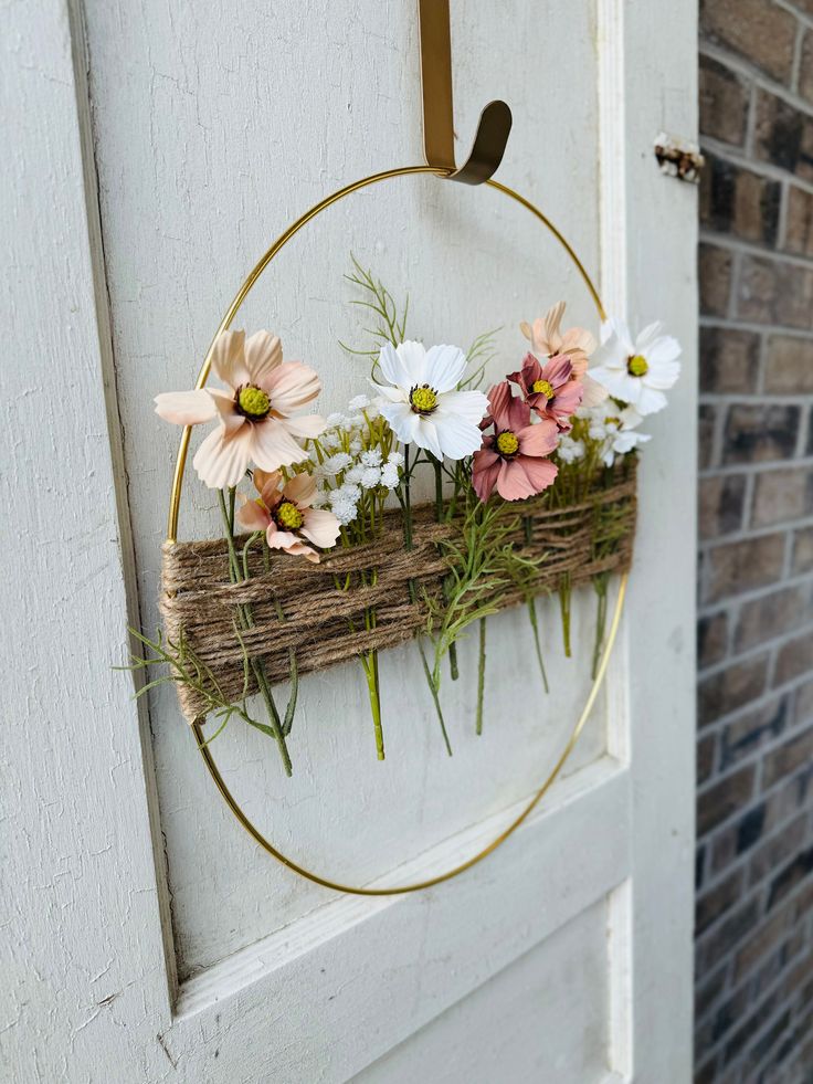 a wreath with flowers is hanging on the door