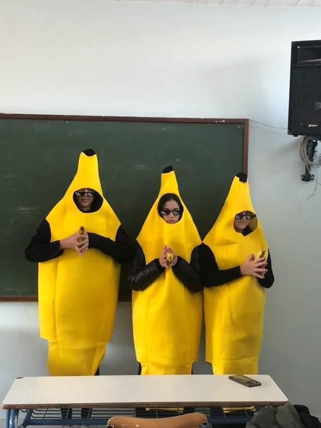 three people in banana costumes standing next to each other