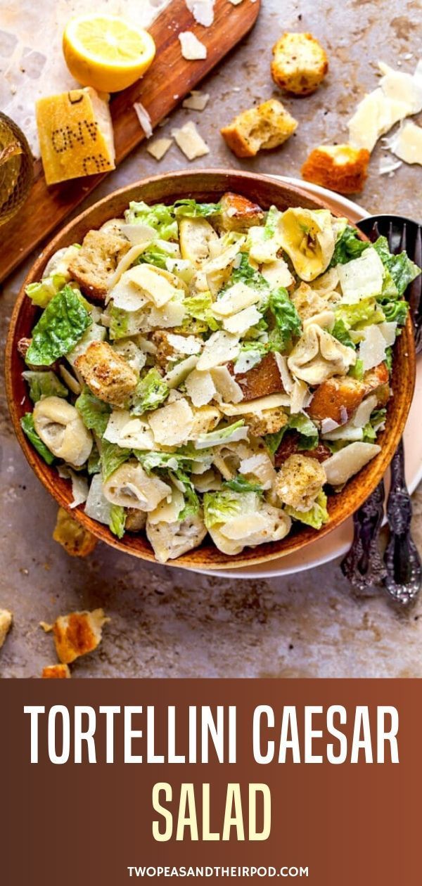 tortellini caesar salad in a bowl with lemons and parmesan cheese on the side