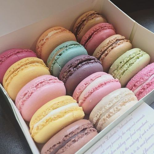 there are many different colored macaroons in the box