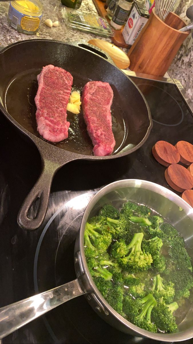 broccoli and meat cooking in a skillet on the stove top with other ingredients