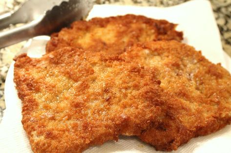 two pieces of fried food sitting on top of a white napkin next to a fork