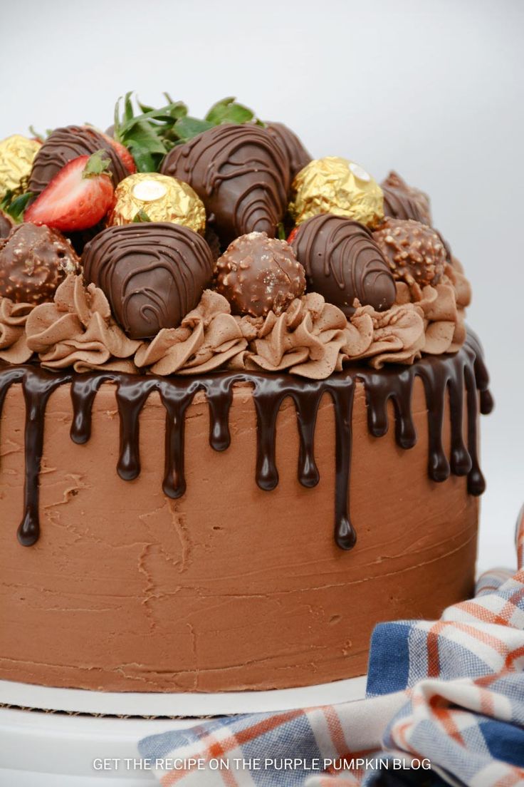 a chocolate cake with strawberries and chocolate drizzle on top