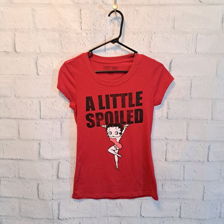 a little sprouted t - shirt hanging on a brick wall with a hanger