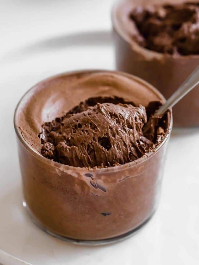 chocolate mousse in a glass bowl on a white plate with the words, the cremest easy chocolate mousse