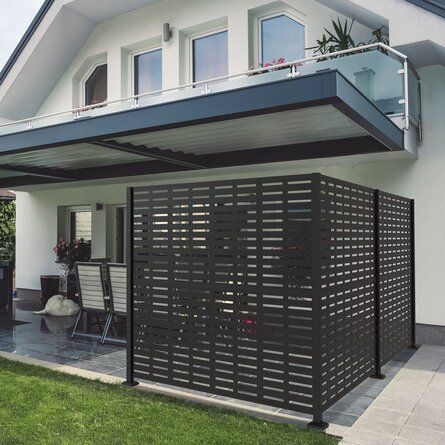 a house that has a black fence in front of it and some grass on the ground