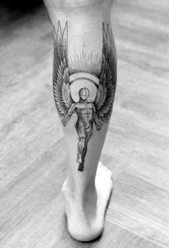 a black and white photo of a person's leg with an angel tattoo on it