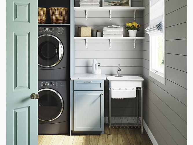 a washer and dryer in a small room next to a door with open shelves