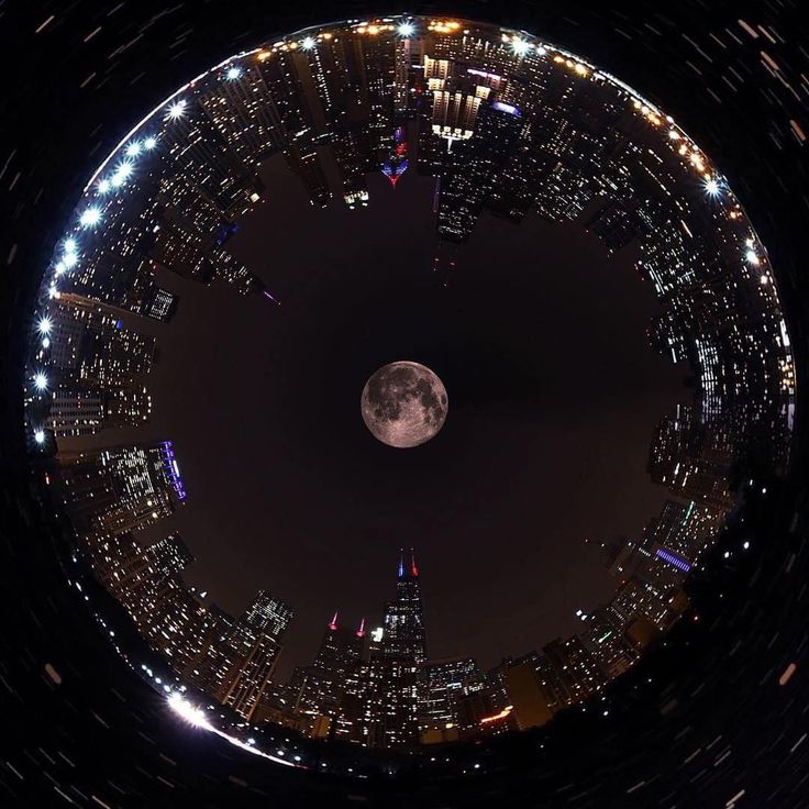 an aerial view of the city skyline at night with a full moon in the sky