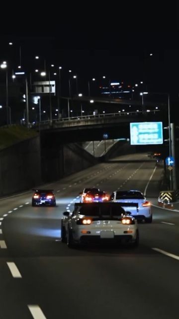 two police cars driving down the highway at night