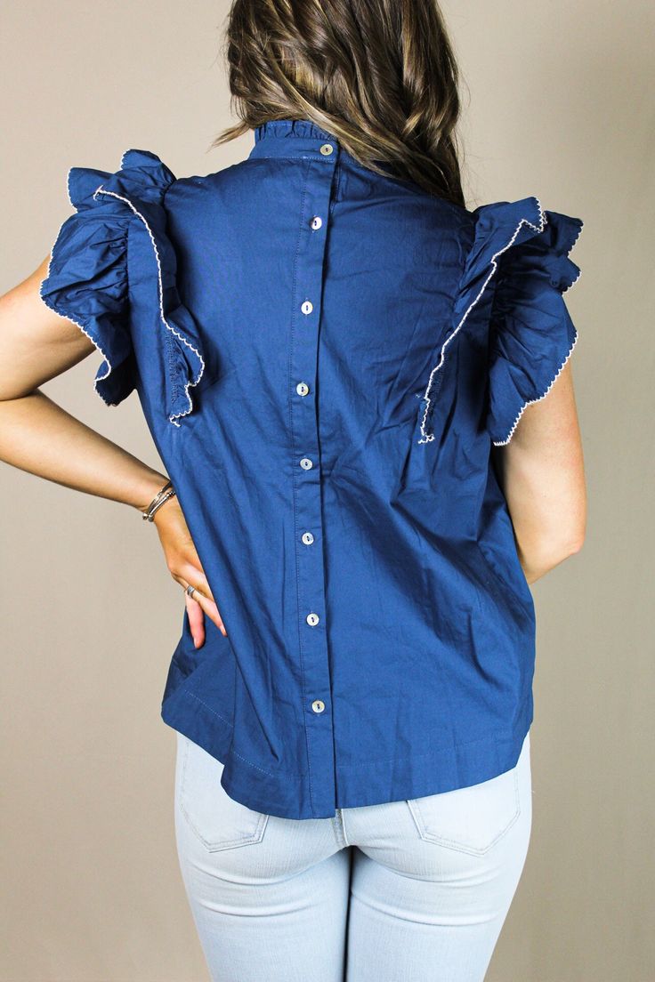 Our "Tessa Top" comes in navy and cream. It is a ruffle sleeved top with pleated details. It buttons down the back and has a smocked neckline. Our model is wearing a size Medium. Casual Blouse With Smocked Back And Flutter Sleeves, Casual Blouse With Flutter Sleeves And Smocked Back, Blue Flutter Sleeve Tops With Ruffle Hem, Blue Tops With Ruffle Hem And Flutter Sleeve, Cotton Smocked Top With Ruffle Sleeves And Details, Chic Navy Short Sleeve Blouse, Navy Chic Blouse For Spring, Chic Navy Blouse For Spring, Elegant Top With Smocked Back And Ruffle Sleeves