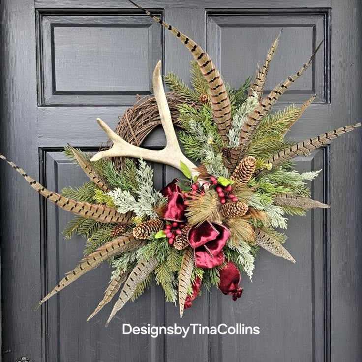 a wreath with antlers and flowers hanging on a door