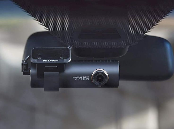 a dash camera attached to the side of a car's rear view mirror,