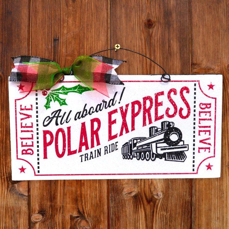 a sign hanging from the side of a wooden fence that says polar express train ride