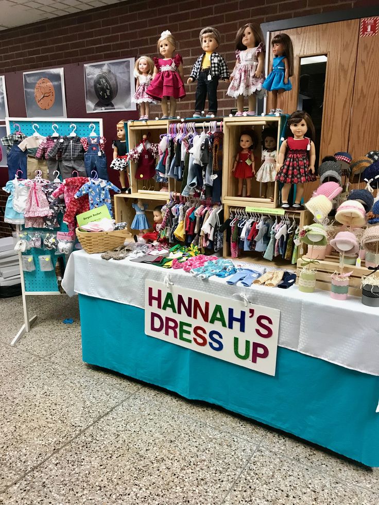 there is a table with many dolls on it and a sign that says hannah's dress up