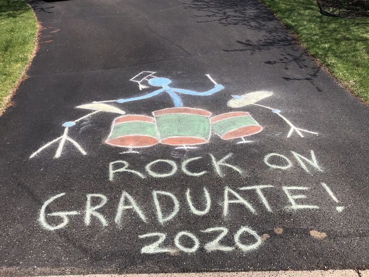 the chalk drawing on the sidewalk says rock on graduate